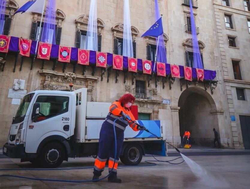 Un equipo de limpieza baldea la Plaza del Ayuntamiento de Alicante