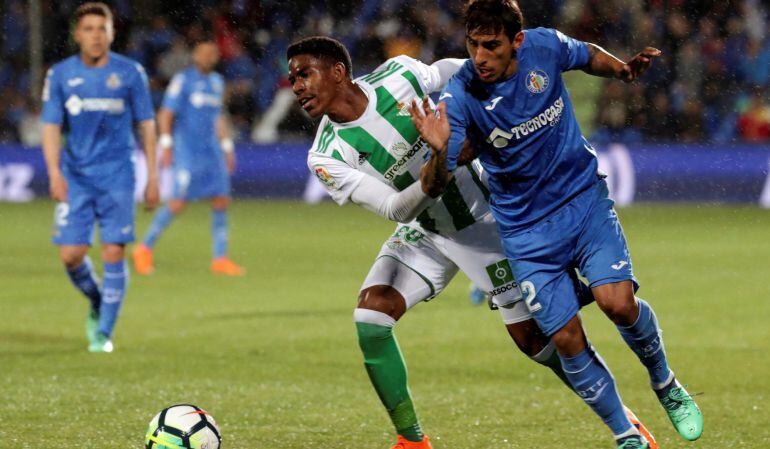 El defensa dominicano del Betis, Héctor Júnior Firpo (i), disputa el balón ante el jugador uruguayo del Getafe, Damián Suárez, durante el encuentro correspondiente a la jornada 30 de primera división que se disputó el lunes.