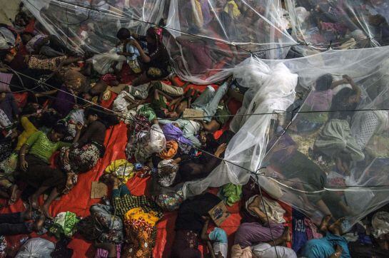 Rohingya migrants from sleep together at the new confinement area in the fishing town of Kuala Langsa in Aceh province on May 16, 2015 where hundreds of migrants from Myanmar and Bangladesh mostly Rohingyas are taking shelter after they were rescued by In