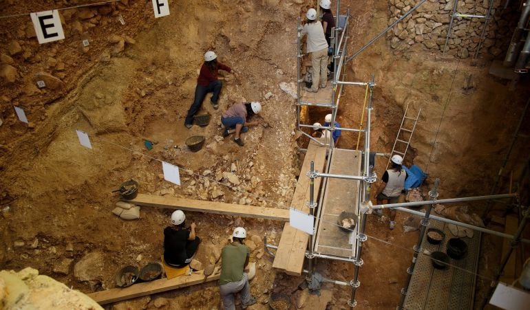 Varias personas trabajan en una cueva en busca de fósiles humanos.