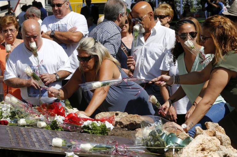 Familiares y amigos de las 154 víctimas del accidente del vuelo de Spanair colocan flores junto a la placa situada al pie del Olivo en los jardines de entrada a la Terminal.