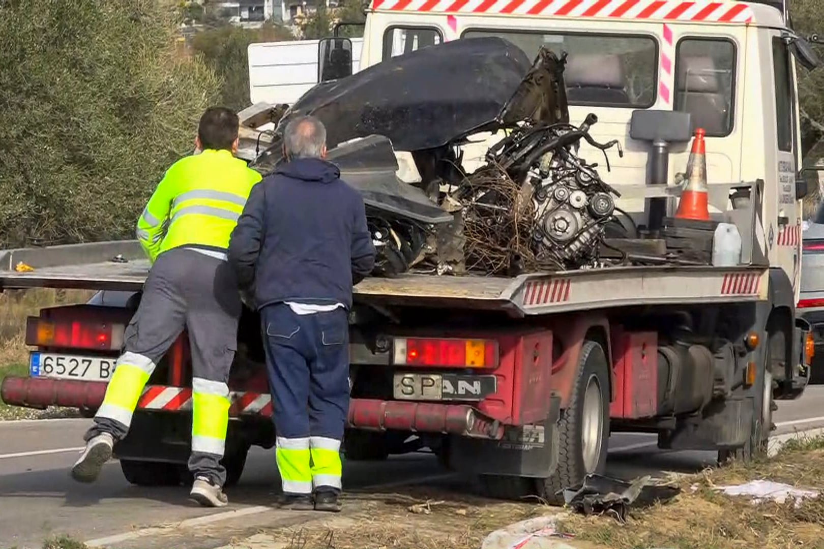 Una grúa se lleva restos de un vehículo tras un accidente.