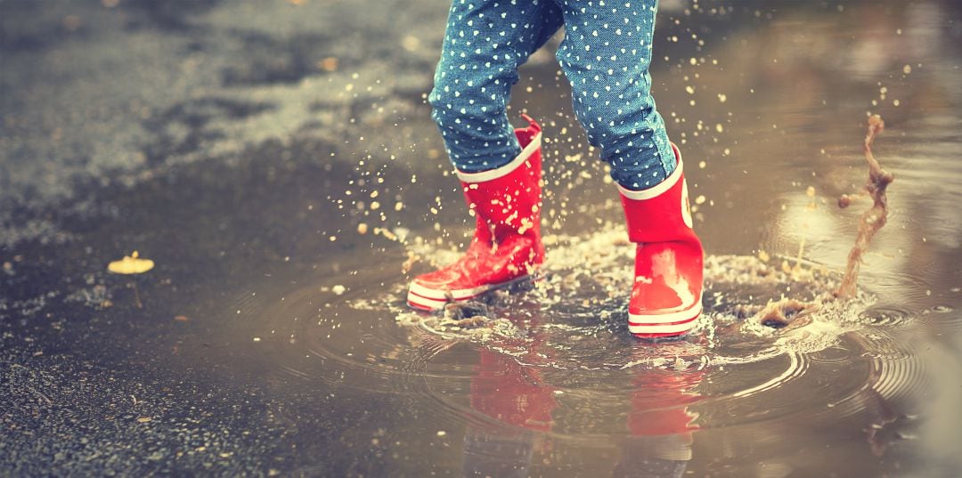 Niña saltando en un charco