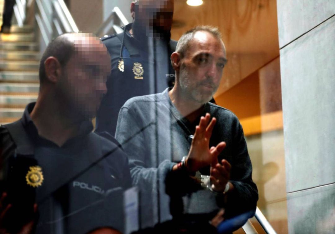 Natalio Grueso, esposado, es conducido de vuelta al centro penitenciario de Asturias tras la suspensión del juicio.