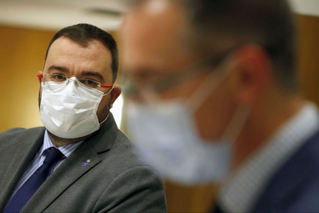 El presidente del Principado, Adrián Barbón, sigue las explicaciones del consejero de Salud durante una rueda de prensa. 