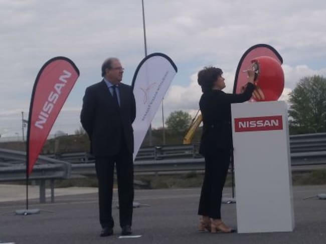 Soraya Saenz de Santamaría pinta una parte del ojo del Daruma mientras Juan Vicente Herrera espera su turno