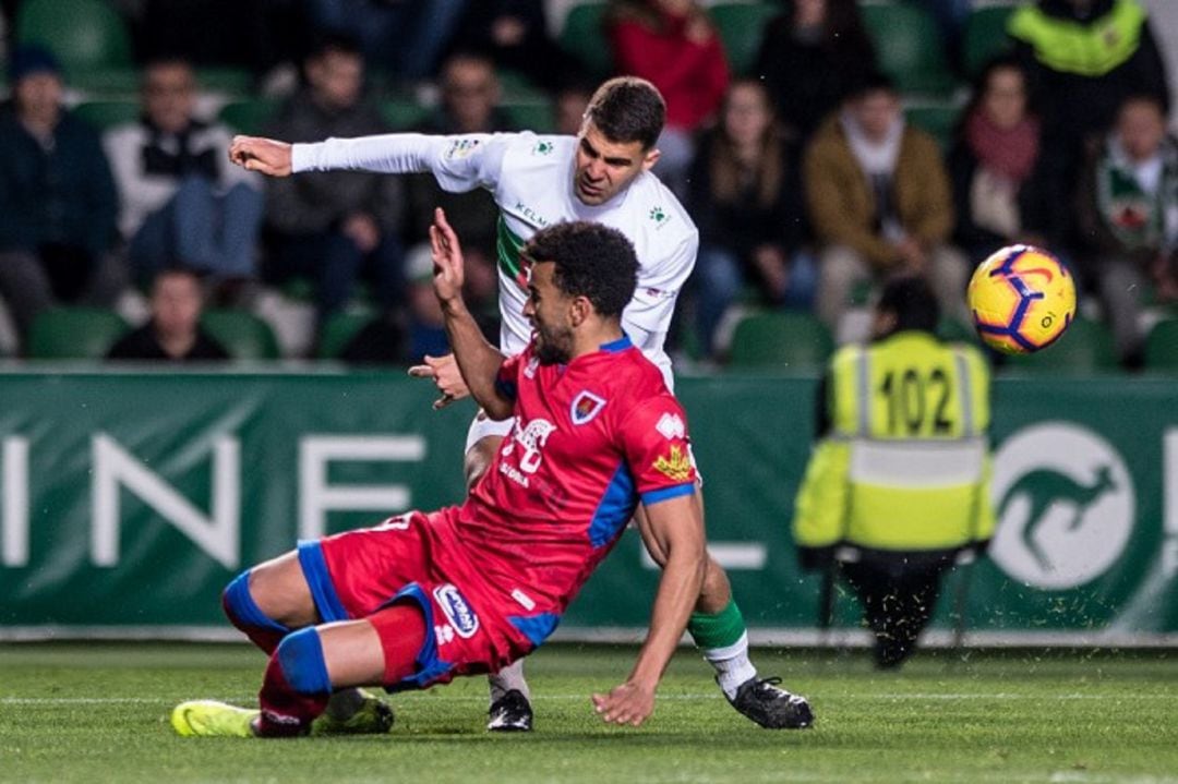 El jugador del Elche, Alexánder, remata con la oposición de un rival