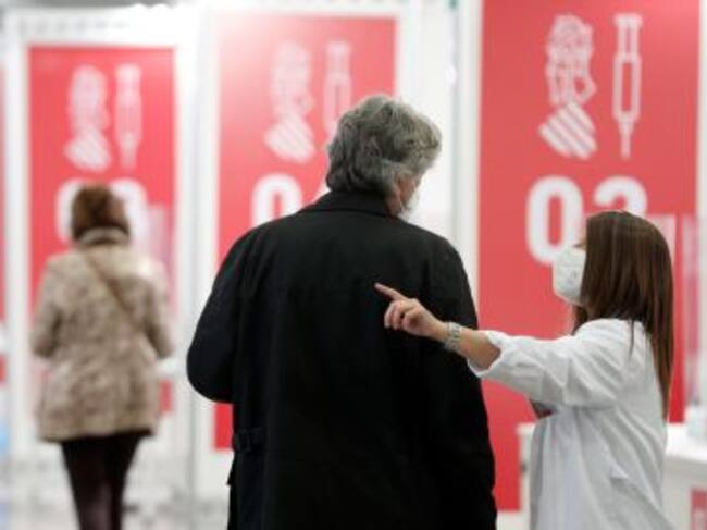 Una enfermera indica a dónde debe dirigirse para vacunarse contra el coronavirus en una de las vacunaciones masivas.