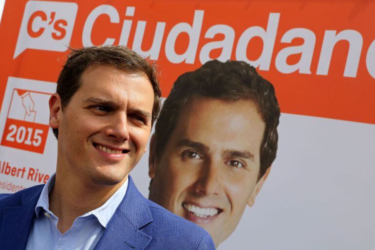Leader of Spanish political party Ciudadanos (Citizens) Albert Rivera looks on past a poster of his party as he meets supporters during the campaign for local elections in Valladolid on May 14, 2015. Spain's new party Ciudadanos and its promise of "reason