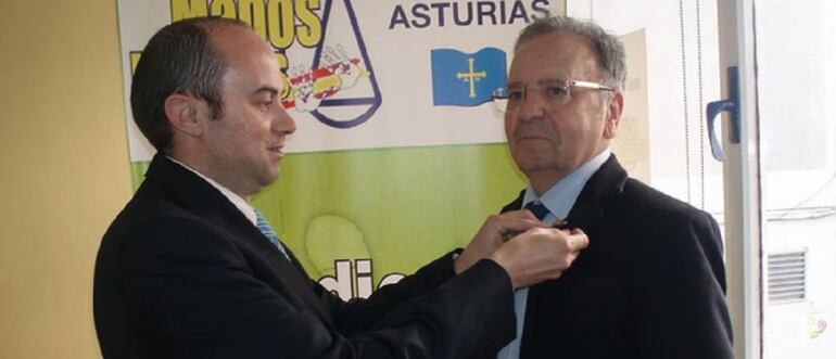 José Alfredo García del Viso, coordinador en Asturias de Manos Limpias, coloca una insignia a Miguel Bernard.