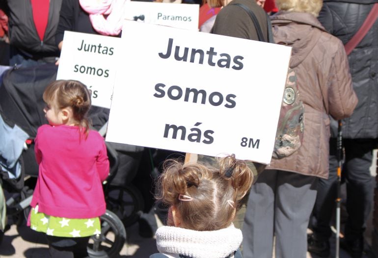 Dos niñas portan pancartas alusivas a la huelga con motivo del Día de la Mujer