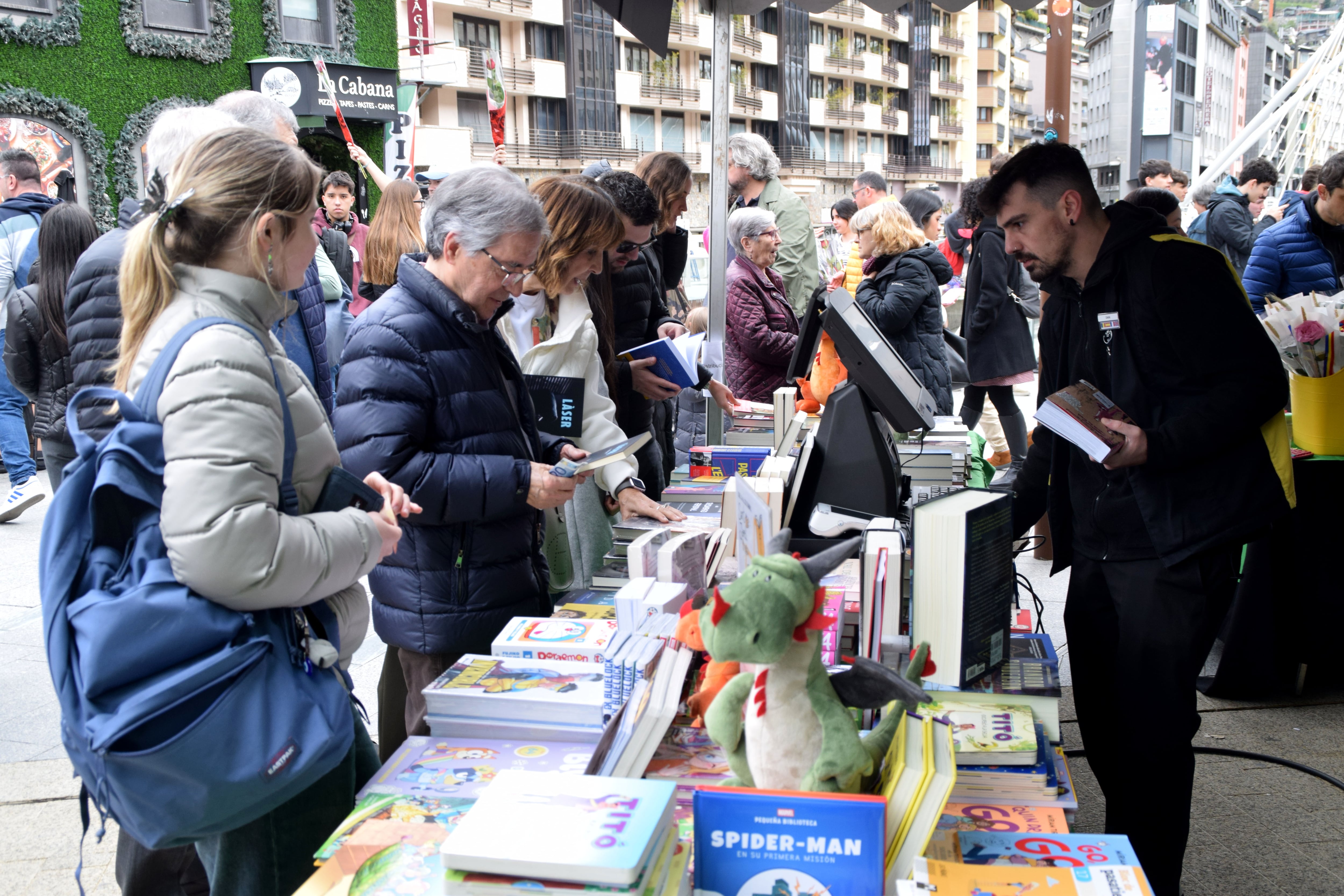 Un grup de persones comprant llibres en una parada d'Andorra la Vella.