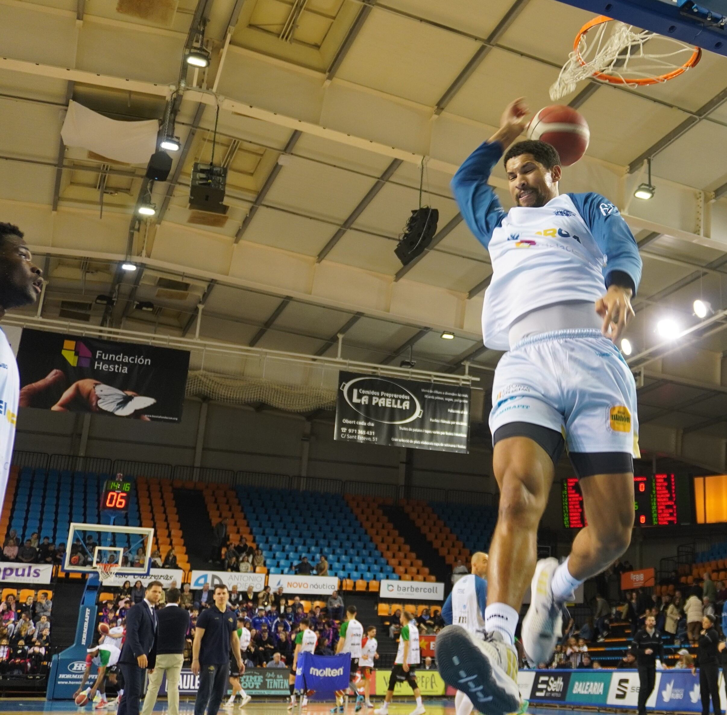 Golden Dike mira com Àlex Tamayo encistella a la roda d'escalfament del partit contra Cantabria.