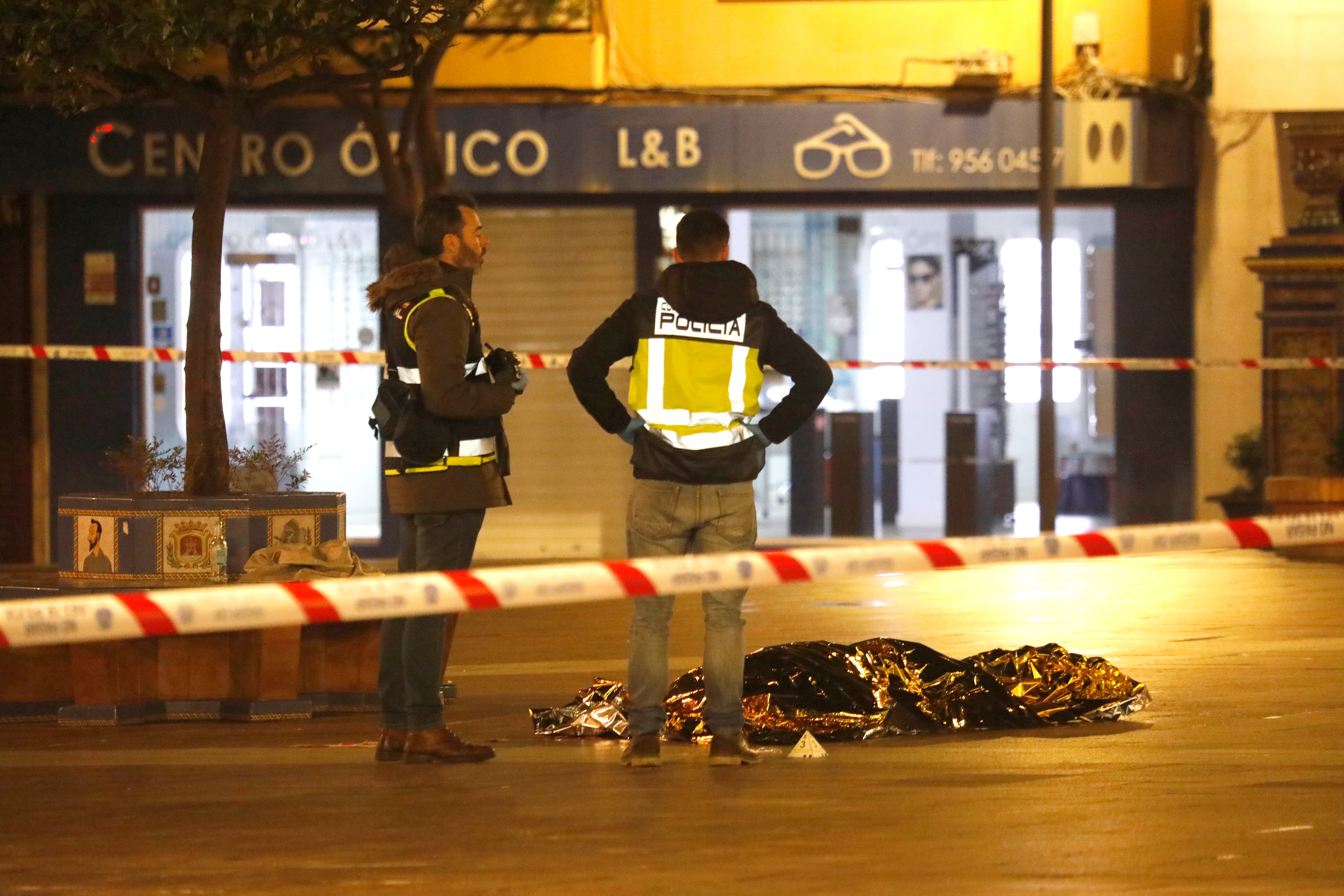 Una persona yace bajo una manta térmica la Plaza Alta de Algeciras este miércoles. Un hombre de origen magrebí ha sido detenido este miércoles acusado de apuñalar mortalmente al sacristán de una iglesia en Algeciras (Cádiz, Andalucía) y de herir a otra persona.