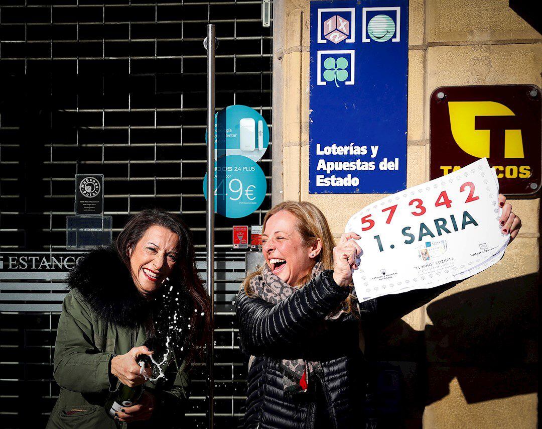 Las responsables de un estanco ubicado en la calle Reina Regente, en el centro de lSan Sebastián, Miren Gurpegi (i) y Ainhoa Tais, se han acercado para brindar con cava tras haber repartido 400.000 euros de el gordo del Sorteo Extraordinario de &quot;El Niño&quot;.