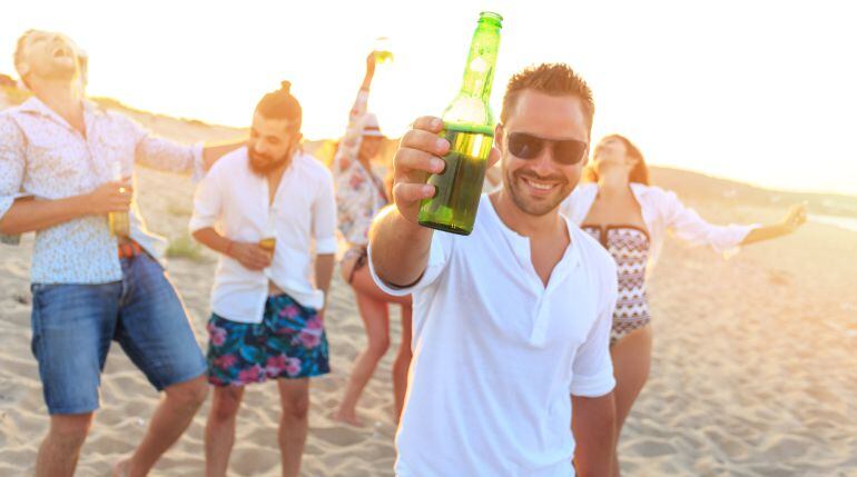 Imagen de un grupo de jóvenes bebiendo alcohol en la playa.