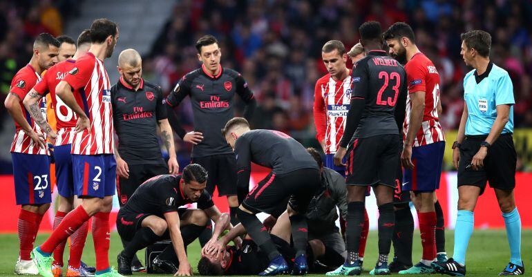 Laurent Koscielny es atendido por los servicios médicos del equipo inglés en el Metropolitano