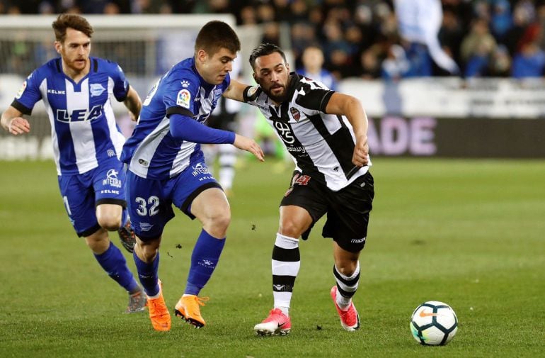 El defensa del Deportivo Alavés Martín Aguirregabiria lucha el balón con Iván López &quot;Ivi&quot; deL Levante