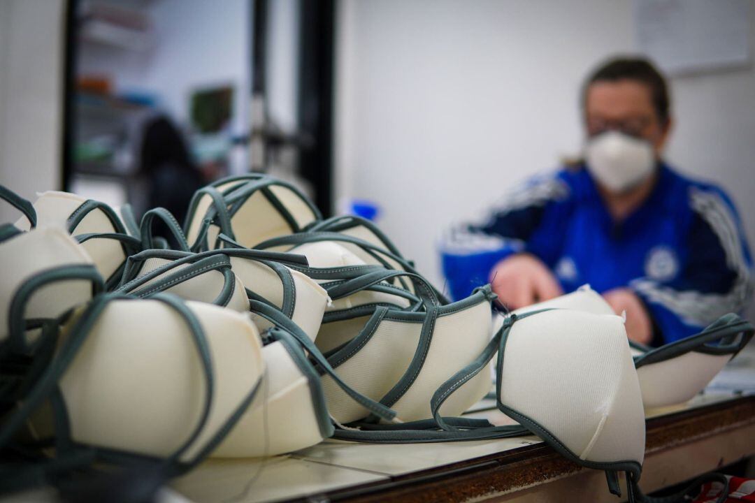 Fotografía de un sastre en italia tejiendo mascarillas