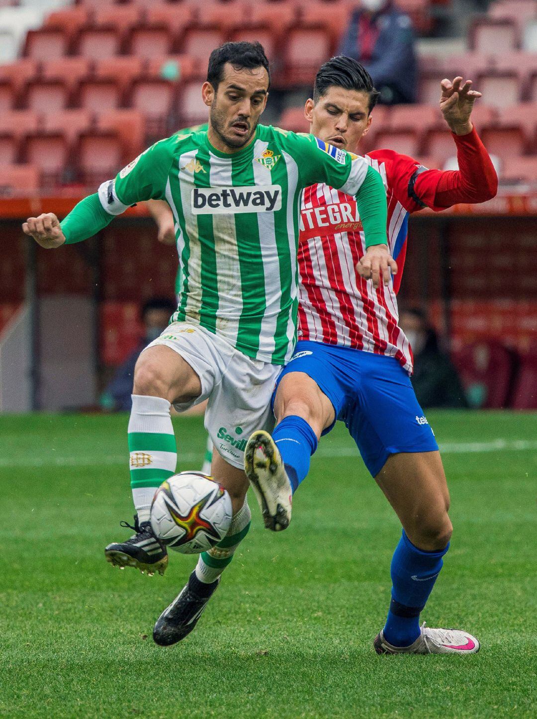 GRAF2529. GIJON (ASTURIAS).- El defensa del Sporting de Gijón Marc Valiente (d) y el delantero del Real Betis Juanmi disputan una posesión durante el partido entre el Sporting de Gijón y el Real Betis de dieciseisavos de final de la Copa del Rey que cuenta con un aforo reducido de 300 personas.EFE Alberto Morante