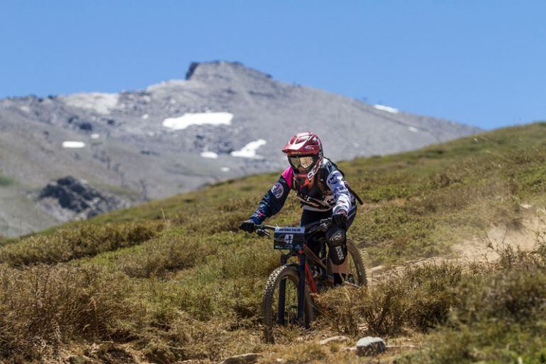 Celebración de una de las carreras de bici de montaña en Sierra Nevada (Granada) con nieve en las cumbres a finales de julio