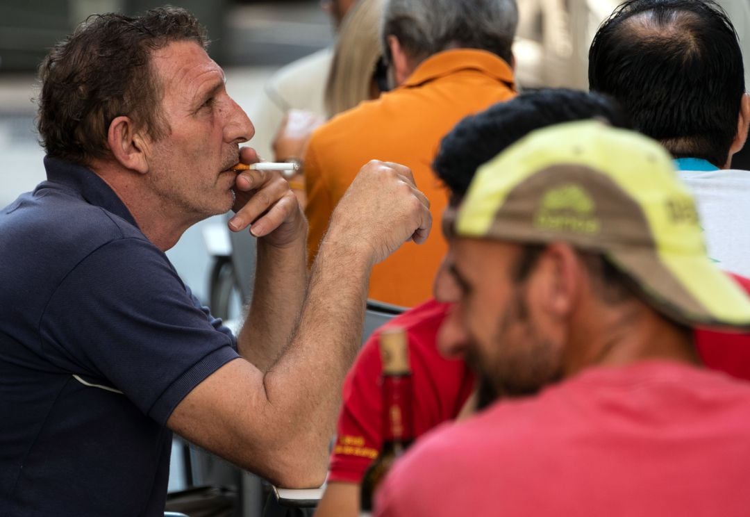 Un hombre fuma en una terraza en Valencia. 