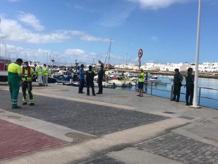 Agentes de la Guardia Civi, efectivos de EMERLAN y operarios municipales en la explanada del puerto de Caleta de Sebo, en La Graciosa.