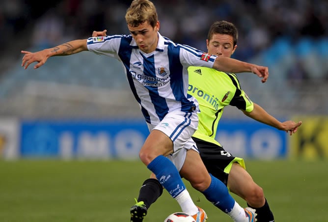 El delantero francés de la Real Sociedad Antoine Griezmann avanza con el balón ante el defensa italiano del Real Zaragoza Maurizio Lanzaro