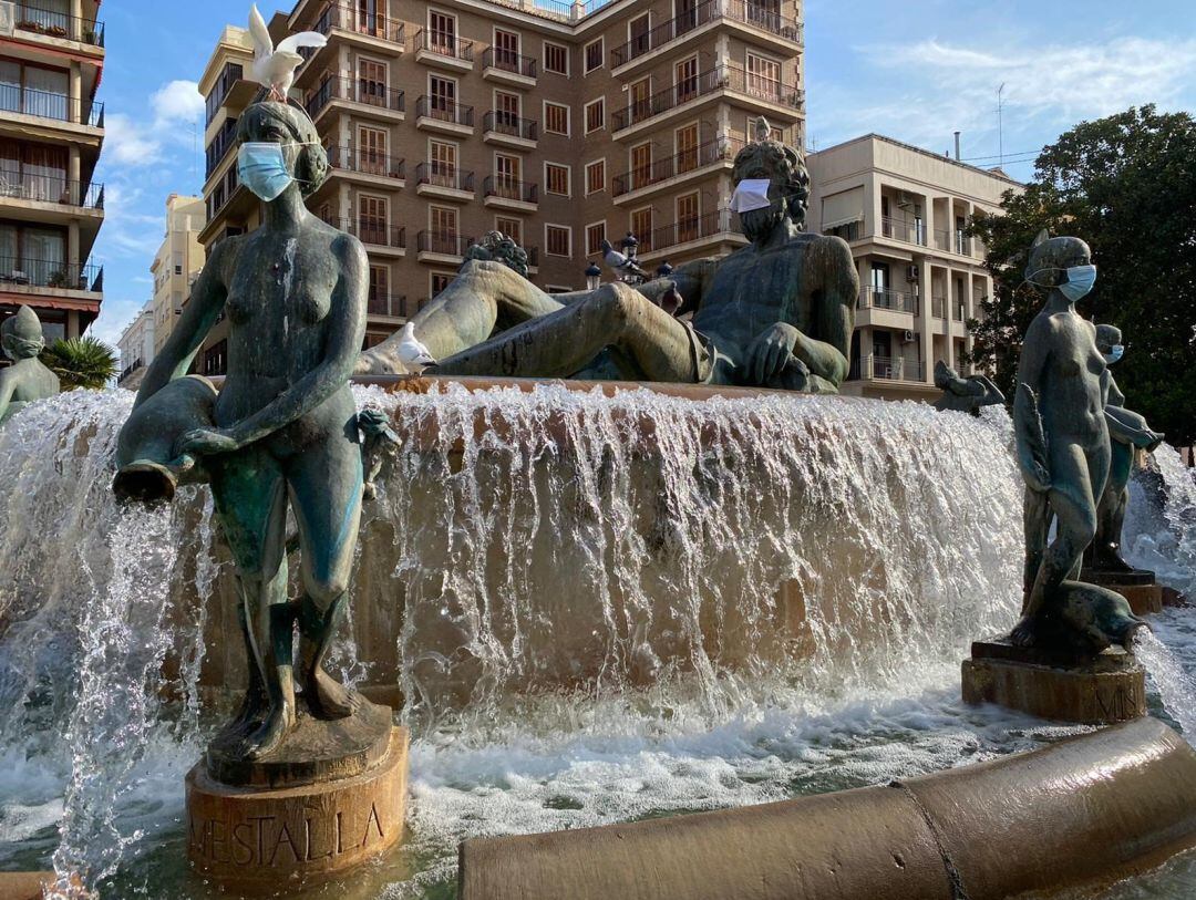Esculturas de la fuente de la Plaza de la Virgen de València con mascarillas para concienciar a la ciudadanía sobre la necesidad de su uso frente de la Covid-19