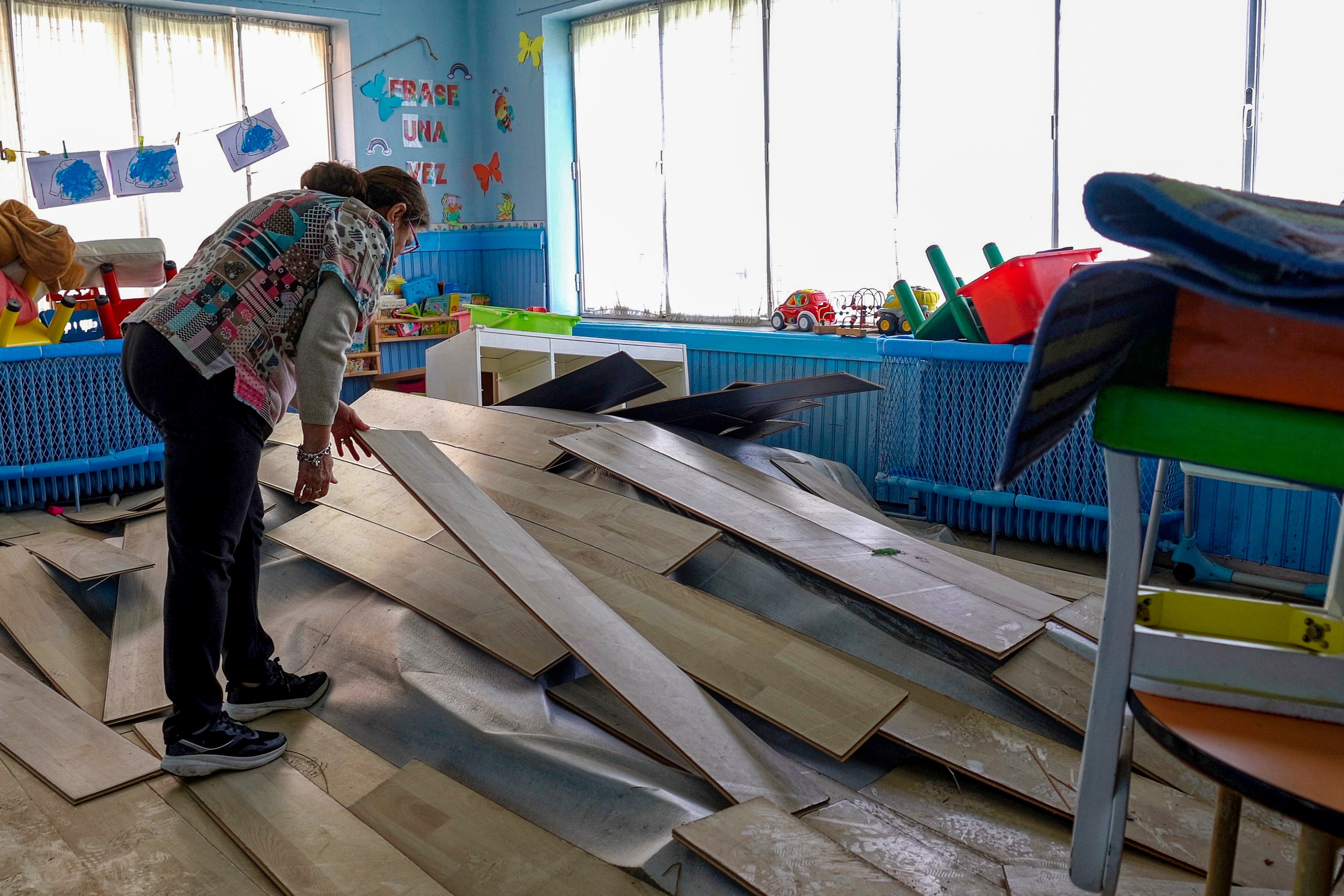 Una mujer observa los daños causados por el agua y la humedad en una guardería afectada por las inundaciones en Ávila