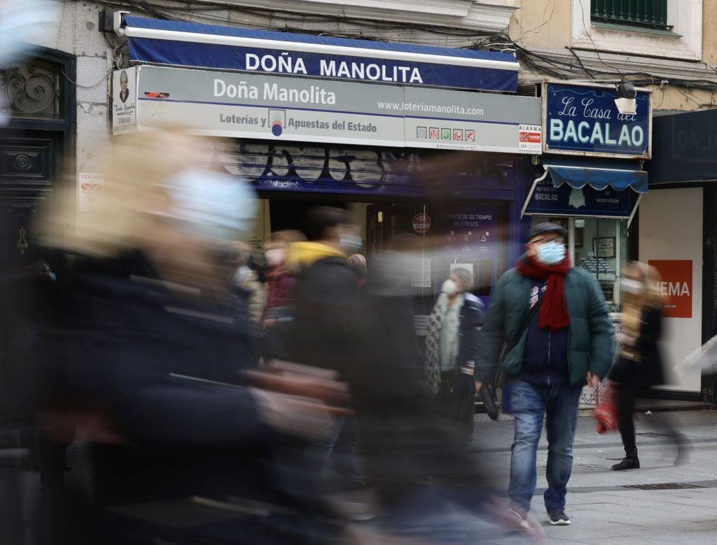 Viandantes pasan frente a la administración de Doña Manolita.