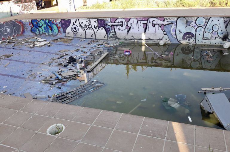 Estado actual de la piscina de Campanillas (Málaga) llena de basura y residuos, sin valle de seguridad y foto de mosquitos