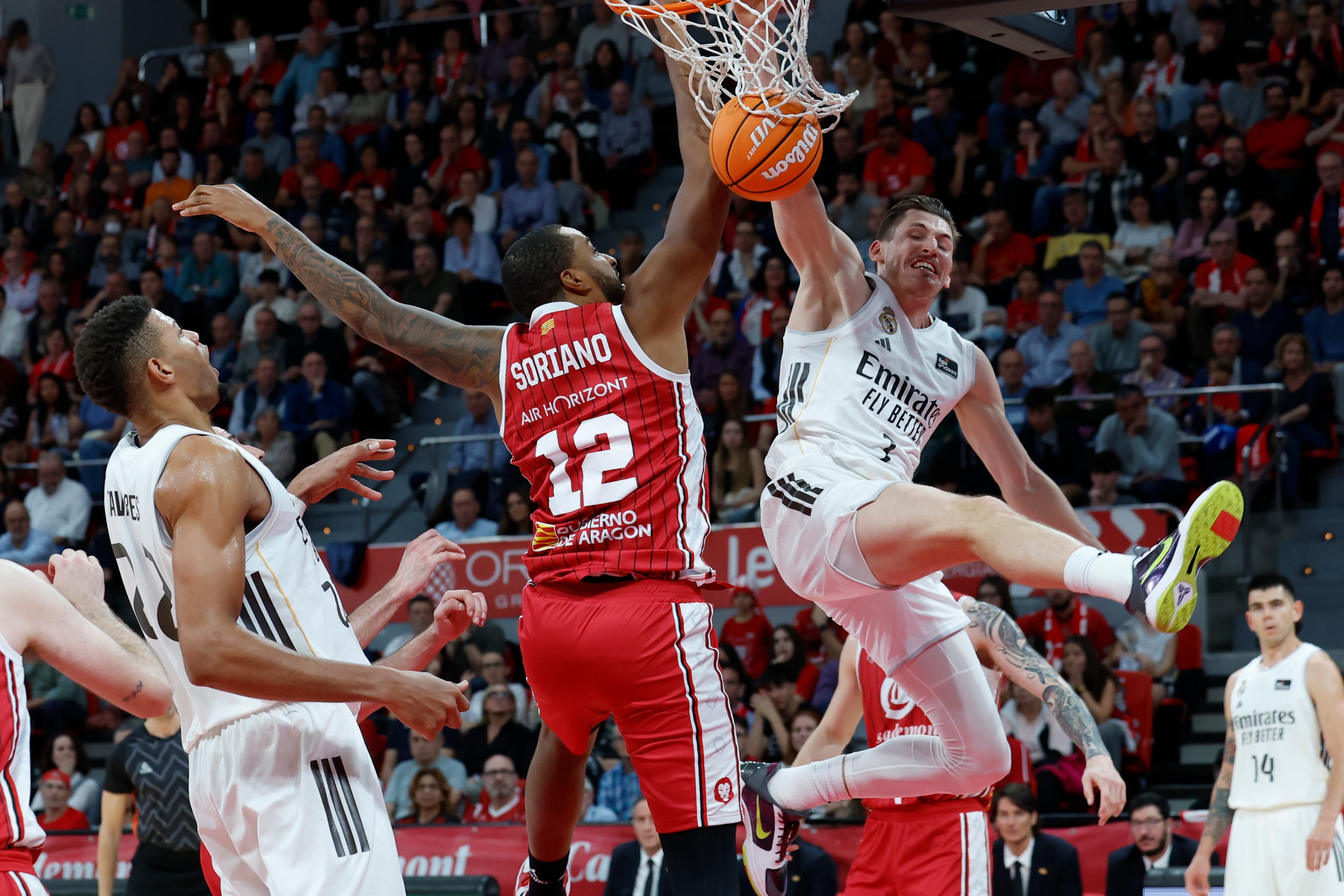 ZARAGOZA, 02/11/2025.- El alero del Madrid David Krämer (d) lucha por el balón con el pívot Joel Soriano (c), del Casademont Zaragoza, durante su partido de la Liga ACB de baloncesto disputado este domingo en el Pabellón Príncipe Felipe de Zaragoza. EFE/ Javier Cebollada