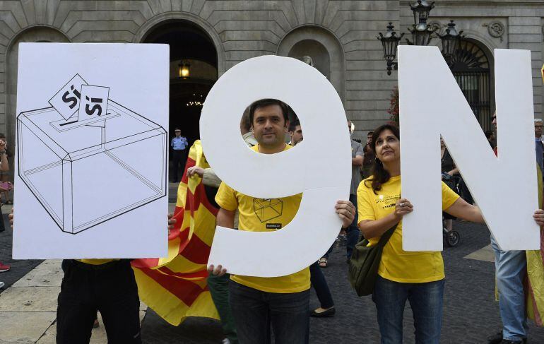 (FILES) A file picture taken on September 27, 2014 shows pro-independence Catalans holding placards representing a ballot box and the date of the vote "9N" as they react on Sant Jaume square after president of Catalonia's regional government Artur Mas signed the regional law to vote on independence on November 9 in Barcelona in Barcelona. Spain's Constitutional Court on November 4 blocked a symbolic independence referendum planned by the wealthy northeastern region of Catalonia on November 9 at the request of the nation's central government. AFP PHOTO / LLUIS GENE