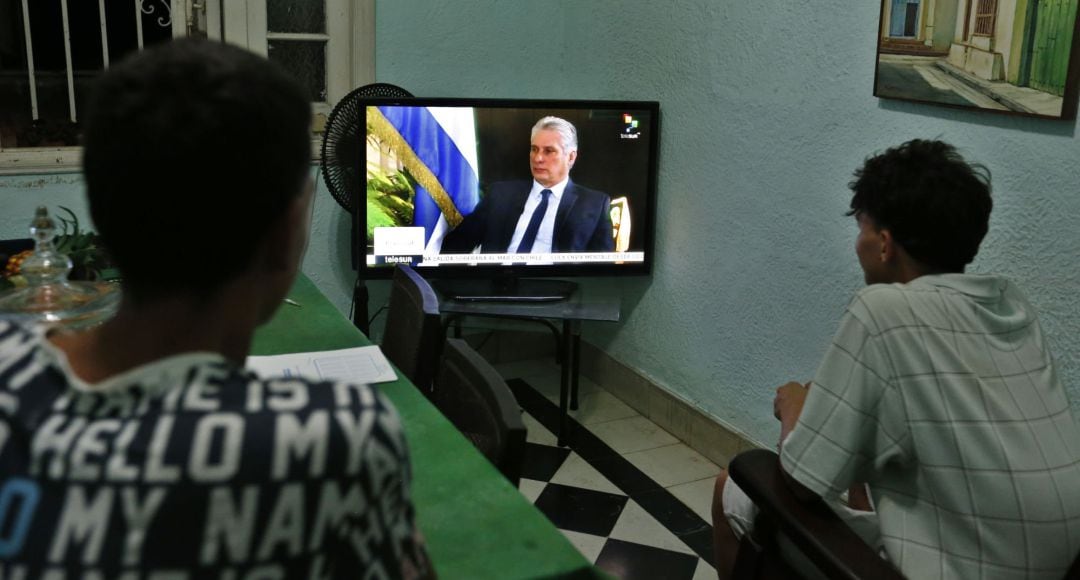 Dos jóvenes ven la entrevista al presidente cubano, Miguel Diaz-Canel, de la cadena de televisión TeleSur