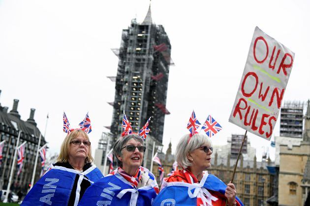 Tres mujeres afines al &#039;brexit&#039; portan banderas y una pancarta con el lema &quot;Nuestras propias reglas&quot; en las inmediaciones de la Plaza del Parlamento en Londres.