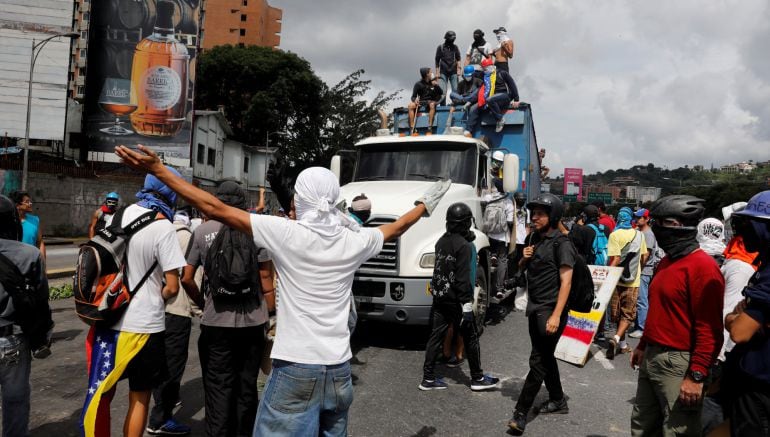 Manifestantes bloquean a un camión durante las protestas en Caracas