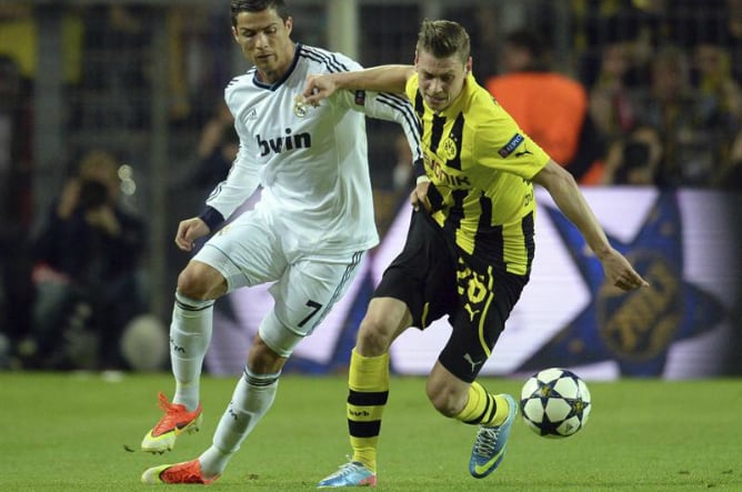 El delantero luso del Real Madrid Cristiano Ronaldo lucha por el balón con el defensa polaco Lukasz Pisczek, del Borussia Dortmund, durante el partido de ida de las semifinales de la Liga de Campeones.