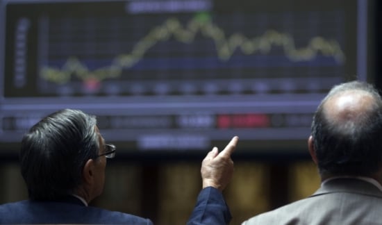 Operadors parlant davant l'índex de la Borsa de Madrid