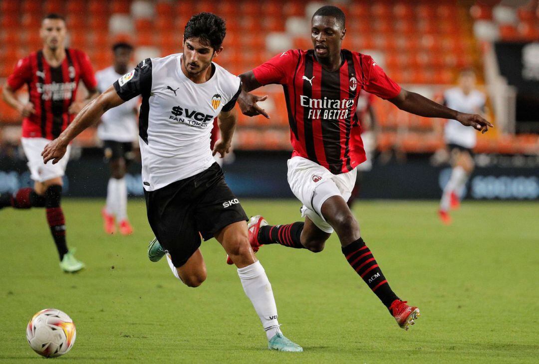 El centrocampista portugués del Valencia CF,Gonçalo Guedes, trata de controlar un balón ante el defensa senegalés del AC Milan, Fodé Ballo-Touré, durante la disputa de la 49ª edición del Trofeo Naranja esta noche en el estadio de Mestalla.