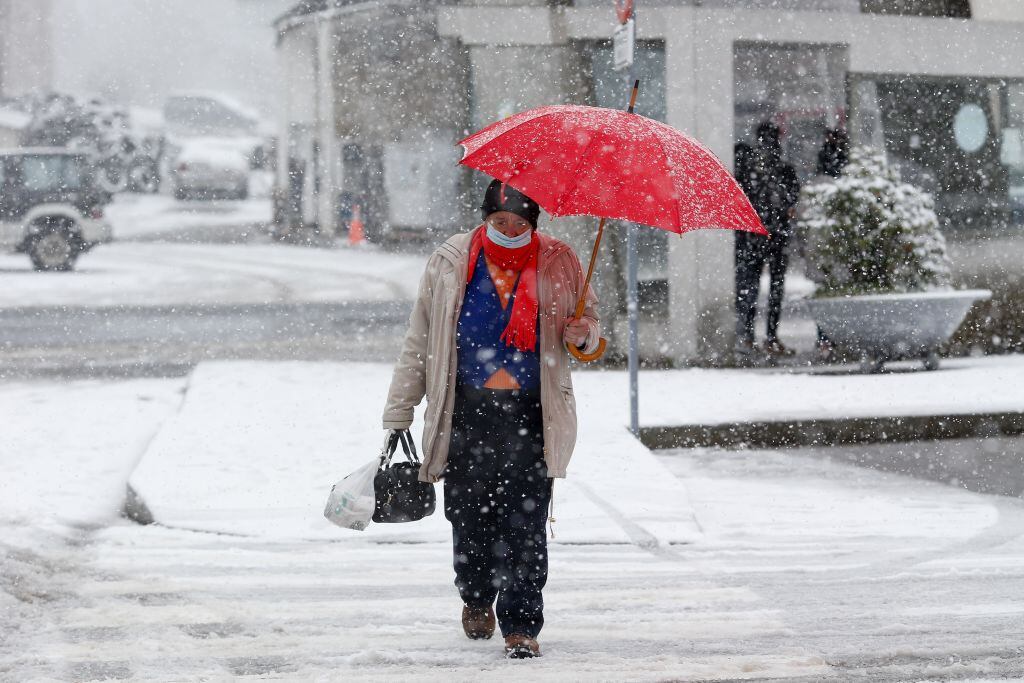 Una mujer se protege de la nieve con un paraguas en Lugo.