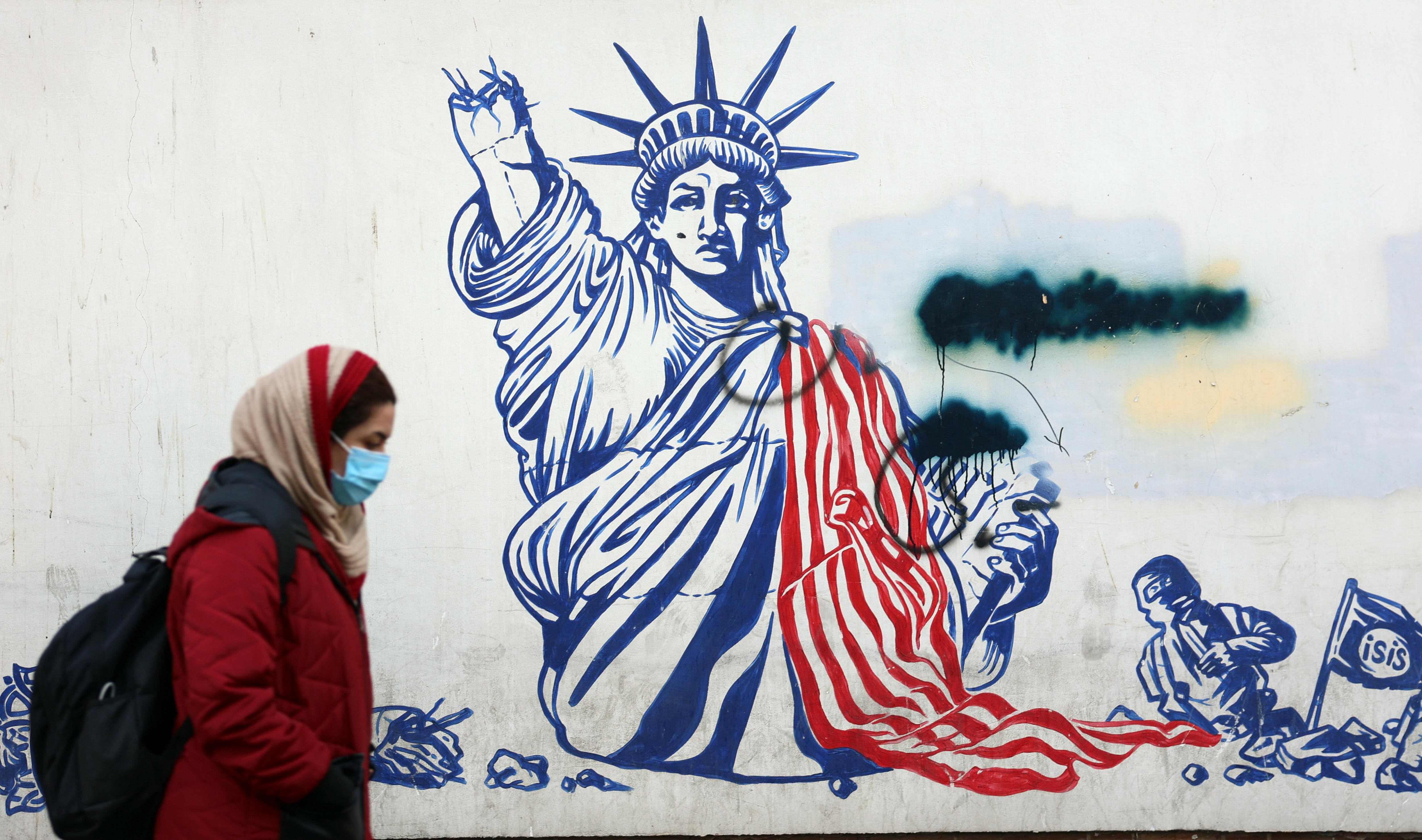 Una mujer iraní pasa delante de una pintada antiestadounidense junto a la antigua embajada de Estados Unidos en Teherán un día después de la vuelta de Trump a la Casa Blanca