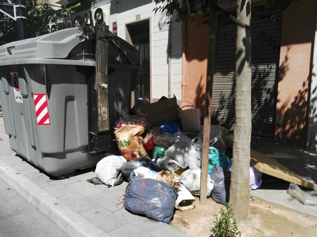 Imagen de un contenedor con basura sin recoger en la avenida de Alcoy