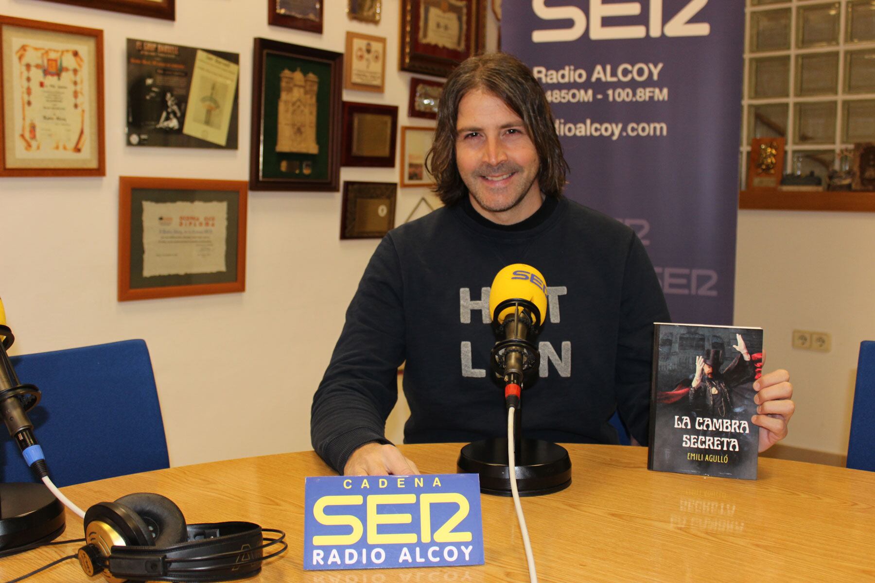 Emili Agulló, en el estudio central de Radio Alcoy, con un ejemplar de su segundo libro