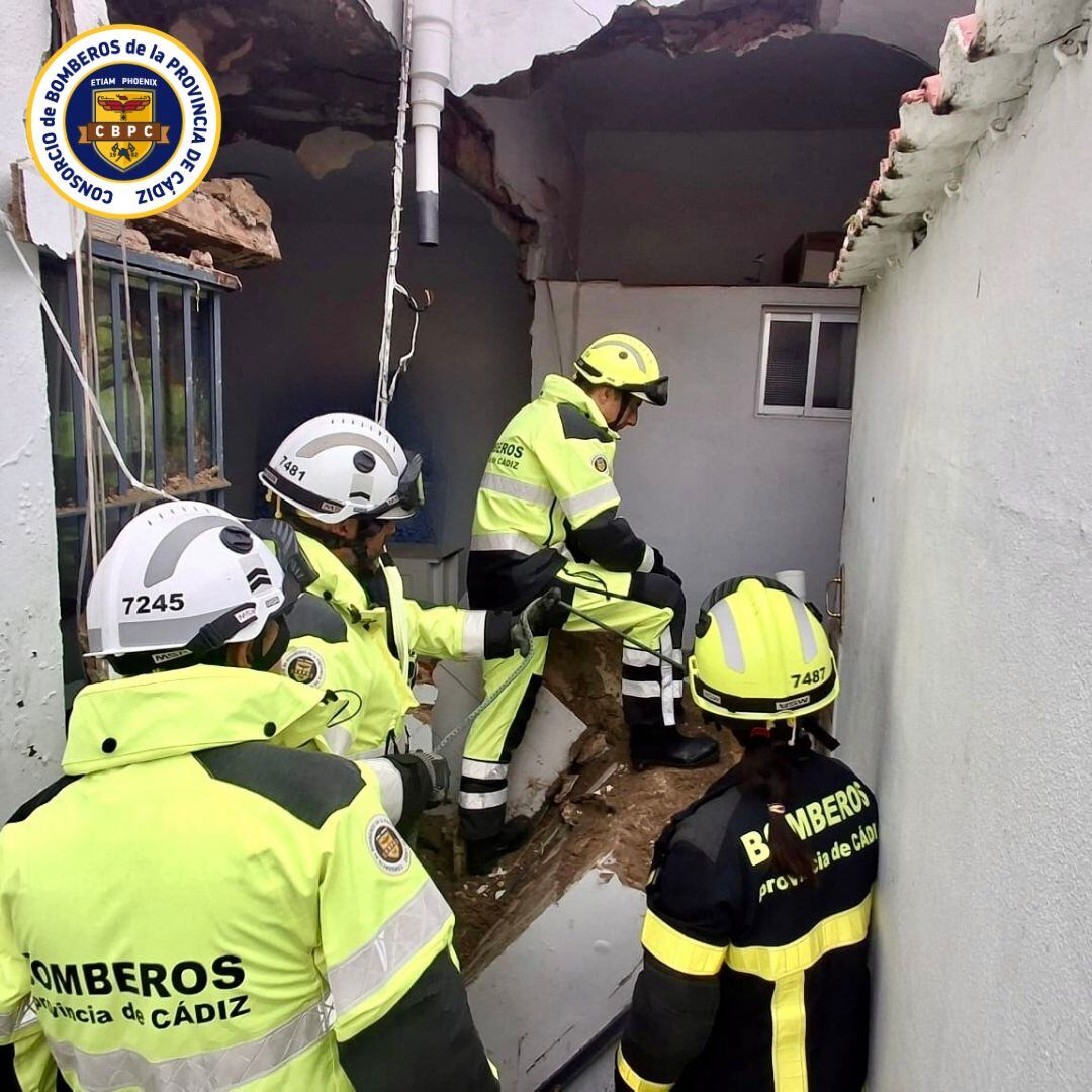 Los bomberos durante el rescate de cinco personas tras colapsar el muro de una vivienda en el barrio de San Miguel, Jerez