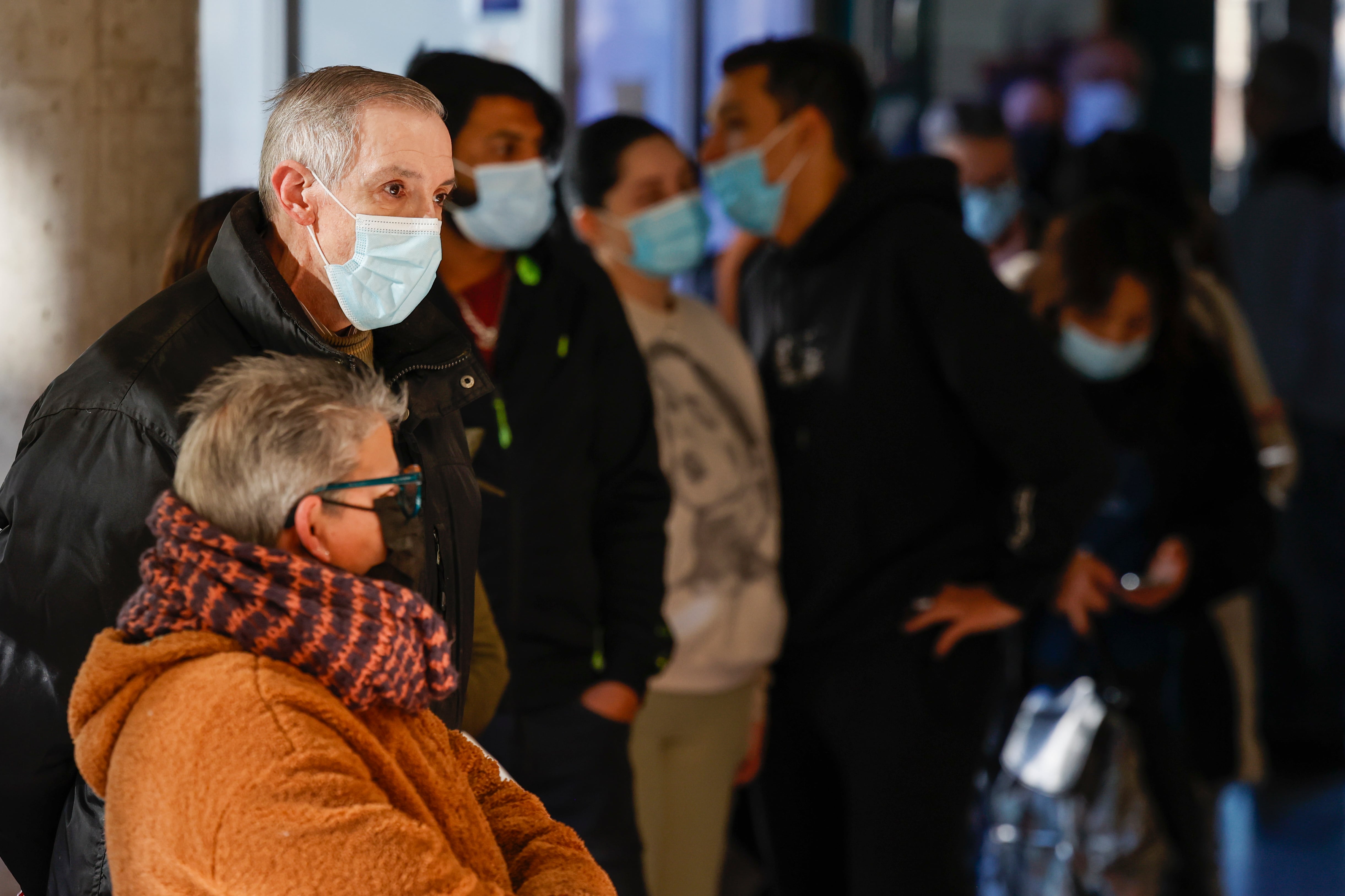 Varias personas guardan cola protegidos con mascarilla ante el repunte de casos de enfermedades respiratorias en un centro de salud valenciano.