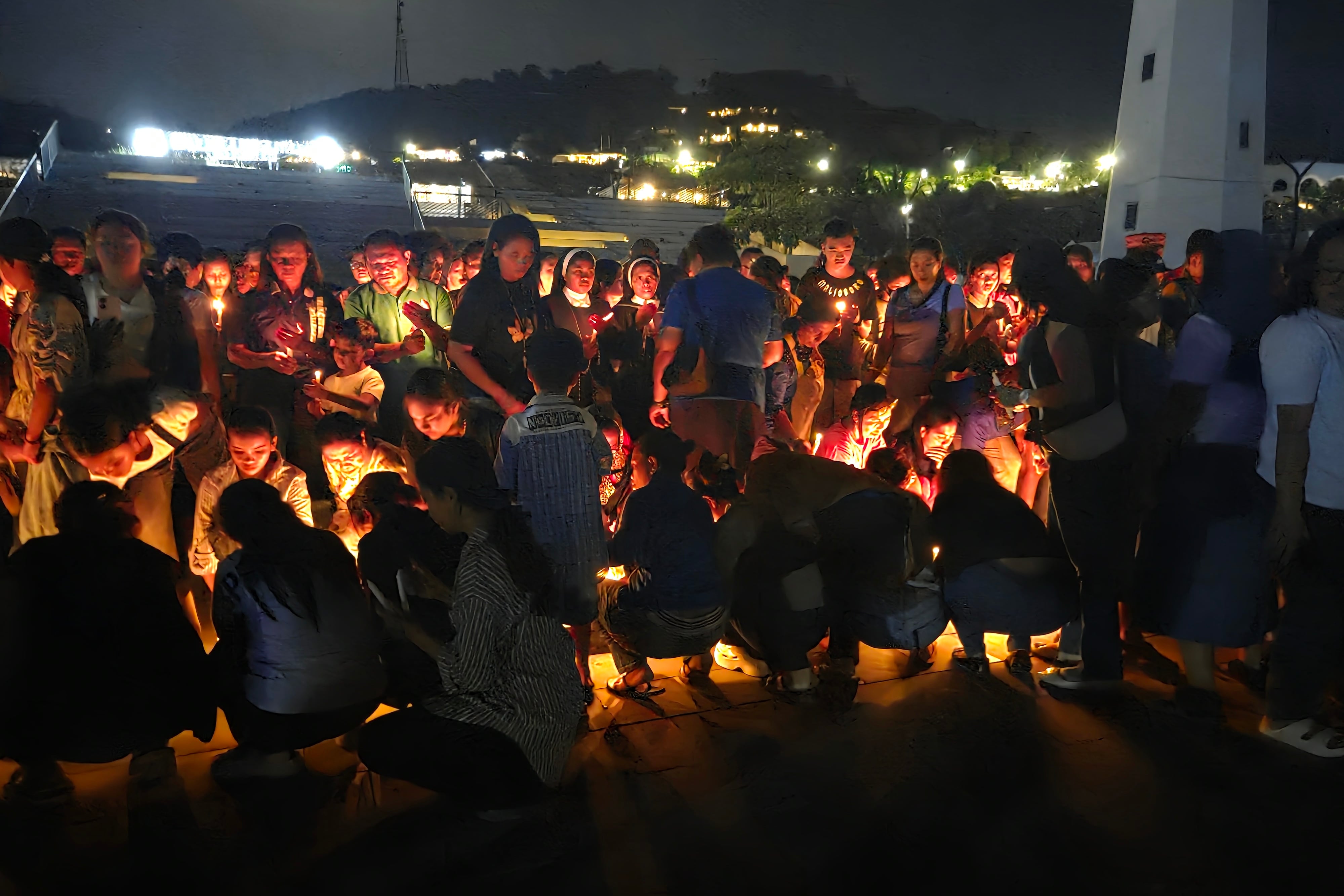 Unas personas participan en una vigilia tras la misión de búsqueda de este viernes de los tres españoles desaparecidos en aguas de Indonesia.