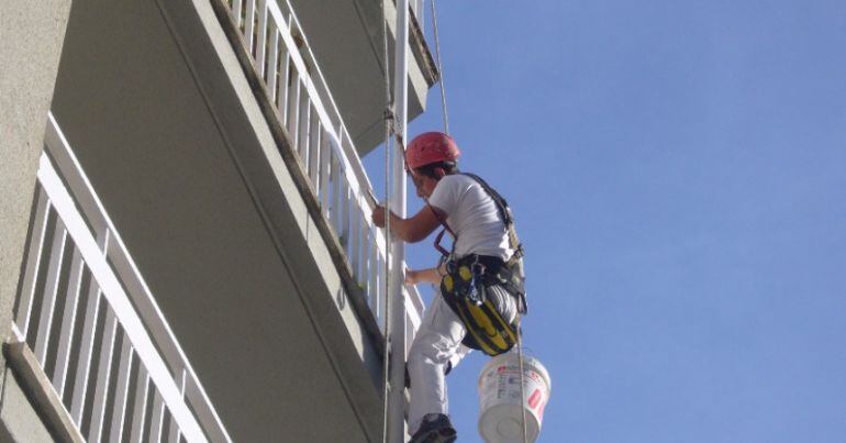 Un operario trabaja en la rehabilitación de una fachada