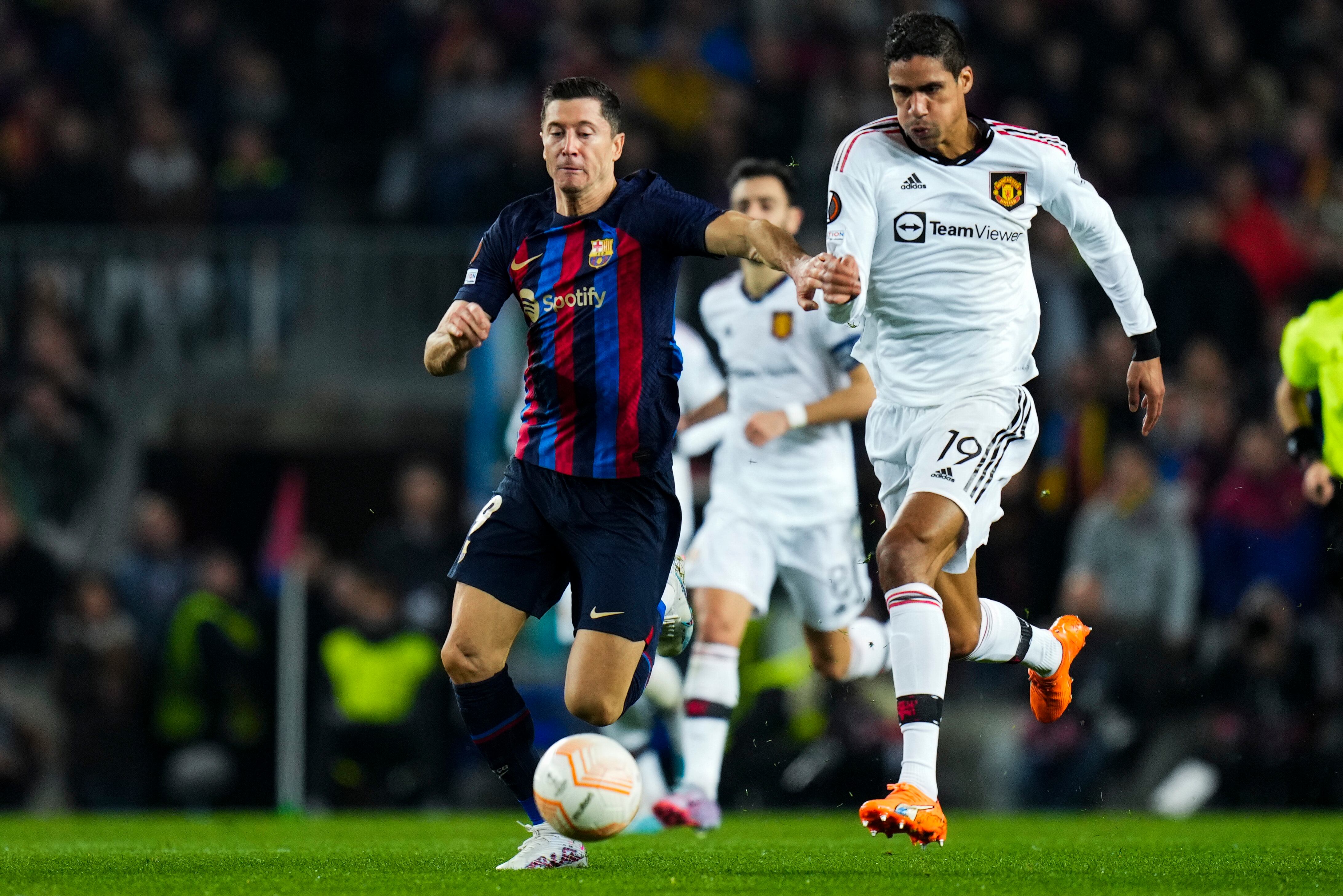 Robert Lewandowski y Raphael Varane en el partido de ida de los dieciseisavos de final de la UEFA Europa League entre FC Barcelona y Manchester United.