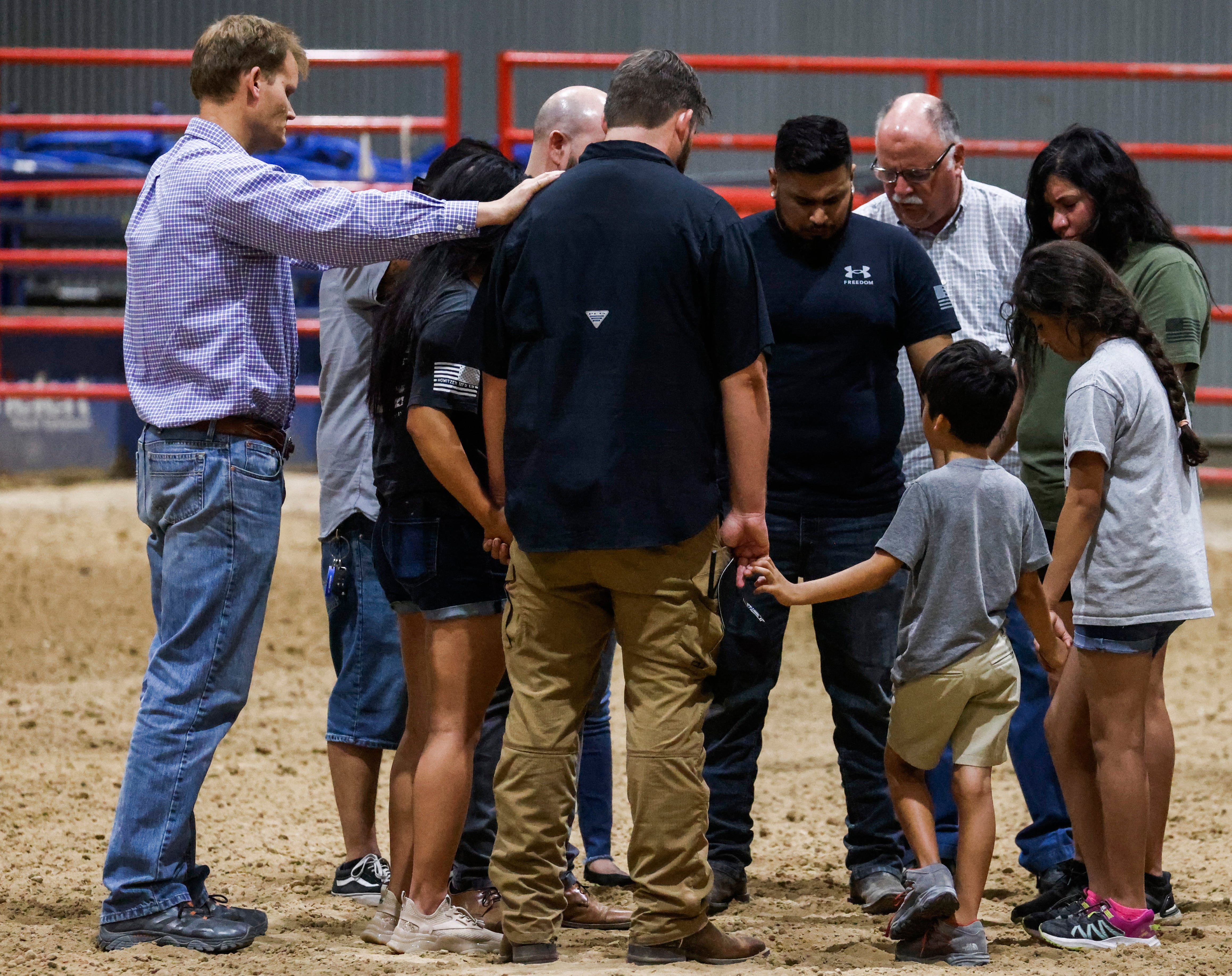 Personas rezando durante una reunión comunitaria en el Uvadle County Fairplex después del tiroteo masivo en la Escuela Primaria Robb en Uvalde, Texas